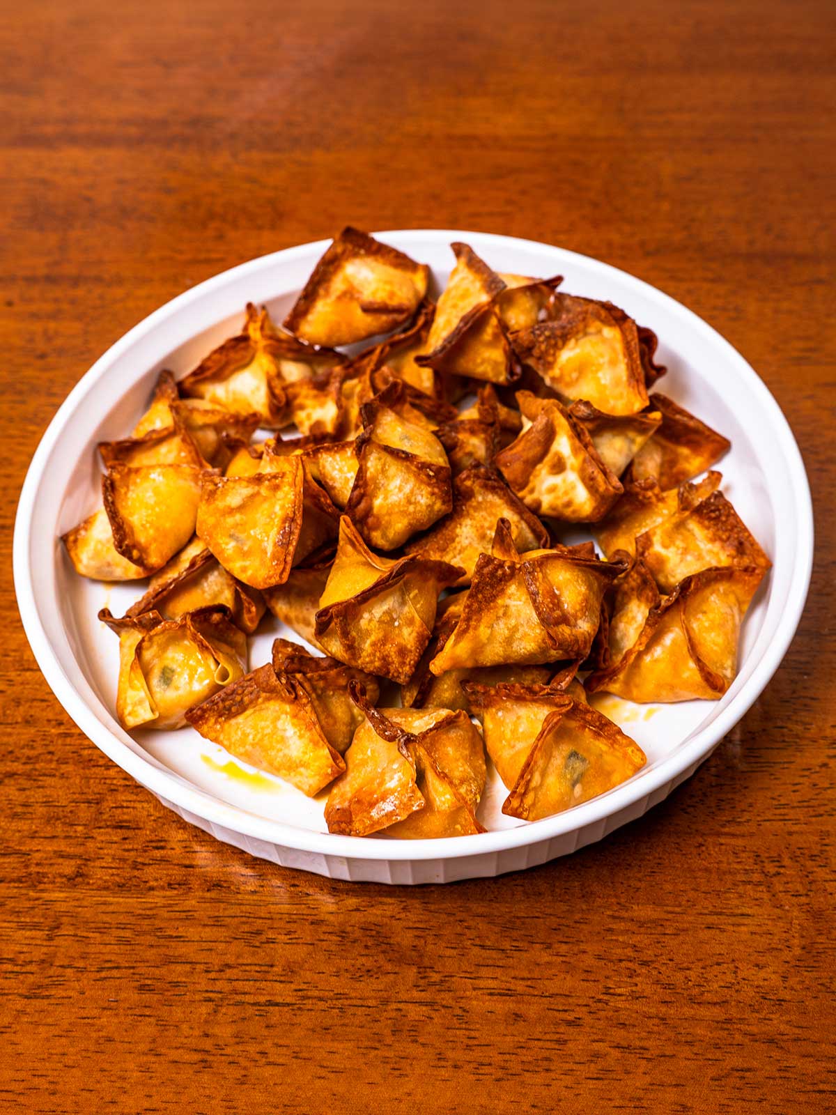 Air fryer buffalo chicken wontons on a plate &ndash; crispy high-protein appetizer with ranch dipping sauce