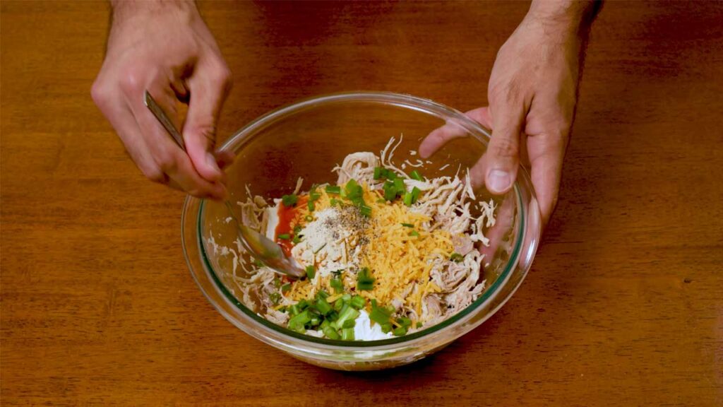 How to make air fryer buffalo chicken wontons &ndash; step 1: mixing cream cheese, shredded chicken and buffalo sauce
