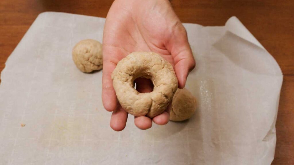 Air fryer whole wheat Greek yogurt bagels close-up &ndash; golden brown high protein bagel on cutting board