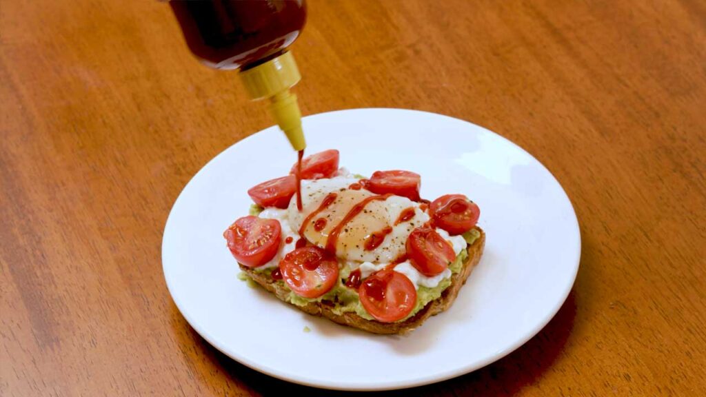 Avocado toast close-up &ndash; creamy high-protein breakfast with visible avocado and egg layers