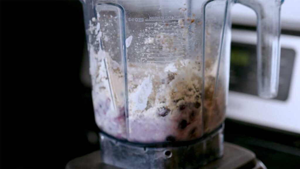 Blueberry cheesecake protein smoothie close-up &ndash; creamy blended smoothie in a glass with blueberries