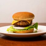 Buffalo burgers on a plate &ndash; spicy high-protein ground turkey burger with melted cheese and toppings