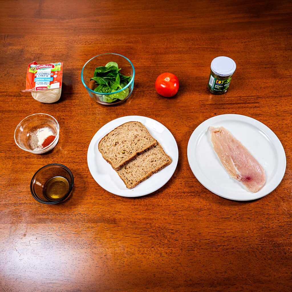 Chicken pesto sandwich ingredients &ndash; grilled chicken, basil pesto, bread, fresh toppings