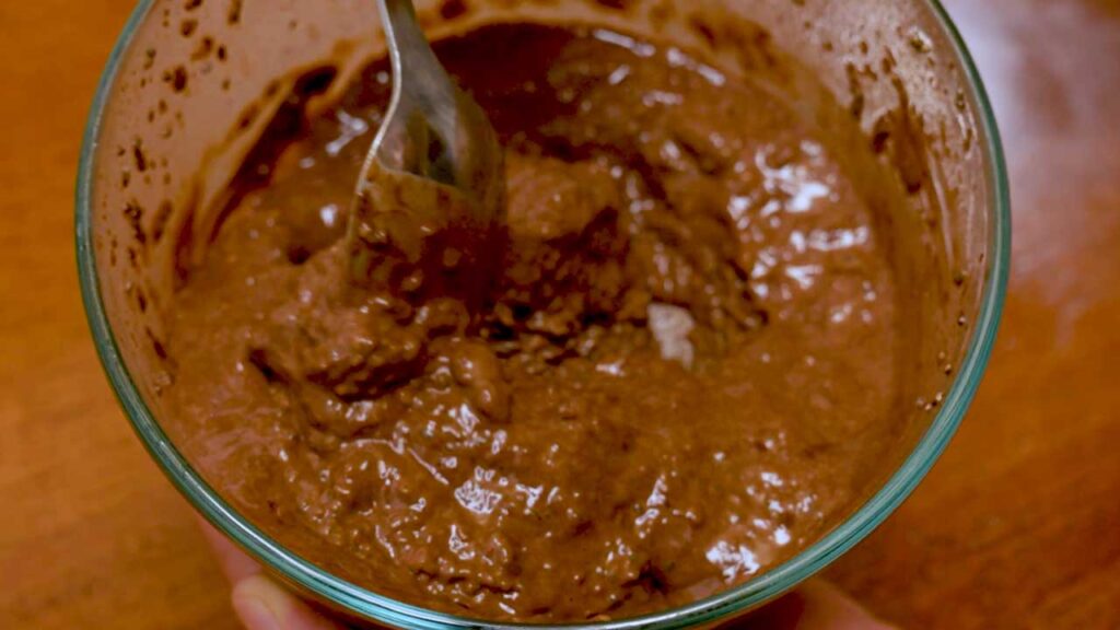 Chocolate chia seed protein pudding overhead shot &ndash; high-protein dessert recipe styled with chia seeds and measuring spoon