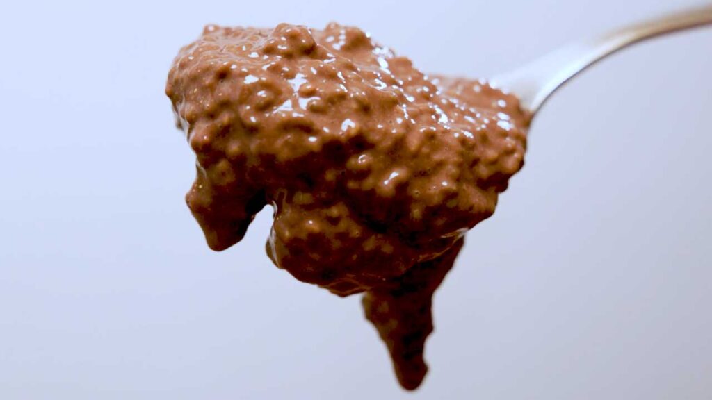 Chocolate chia seed protein pudding ready to eat &ndash; high-protein healthy dessert in glass jar with berries