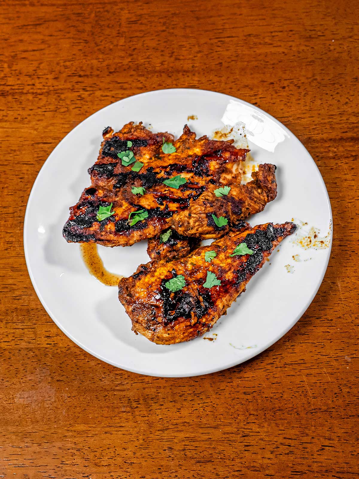 Cilantro lime chicken on a plate with fresh cilantro &ndash; high-protein dinner recipe with lime
