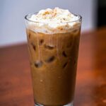 Iced vanilla protein latte &ndash; high-protein creamy coffee drink in glass with ice cubes