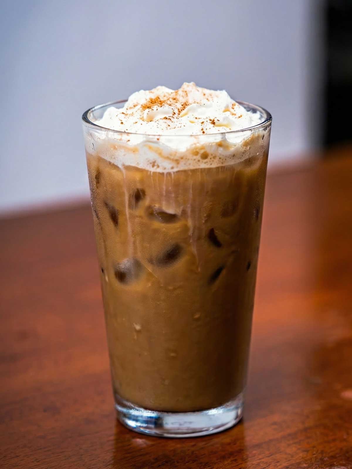Iced vanilla protein latte &ndash; high-protein creamy coffee drink in glass with ice cubes