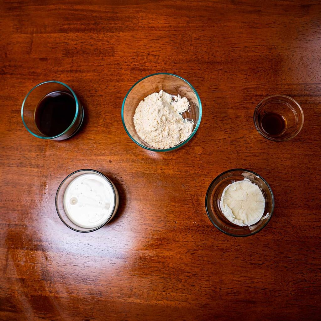 Iced vanilla protein latte ingredients &ndash; milk, vanilla protein powder, espresso for high-protein drink