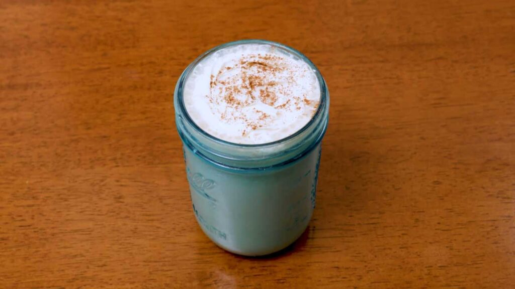Iced vanilla protein latte side view &ndash; high-protein creamy coffee layered with ice cubes