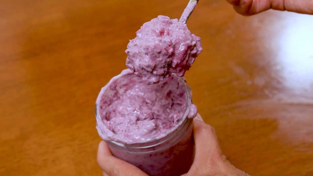 Mixed berry protein cheesecake overnight oats overhead flat lay – high-protein breakfast with ingredients around glass jars