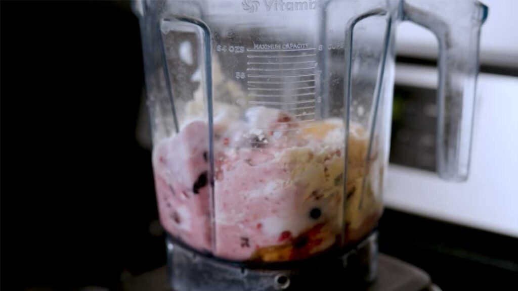 Mixed berry protein shake close-up – creamy high-protein smoothie with fresh strawberries and blueberries