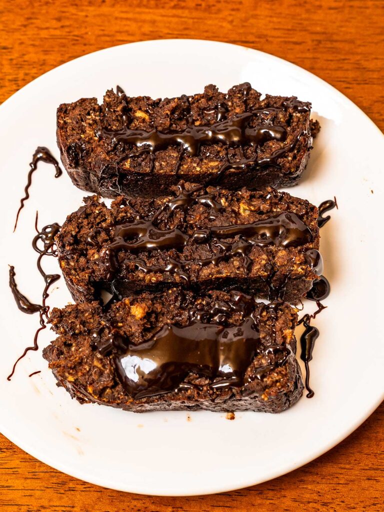 Protein chocolate banana bread recipe &ndash; sliced high-protein loaf with rich chocolate swirl on wooden board