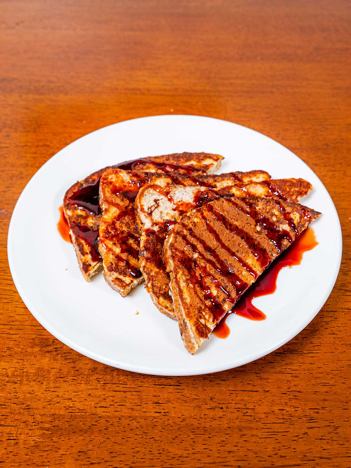 Protein French toast on white plate &ndash; high-protein breakfast with syrup and berries