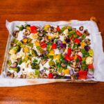 Roasted vegetables medley &ndash; bell peppers broccoli cauliflower and mushrooms on baking sheet