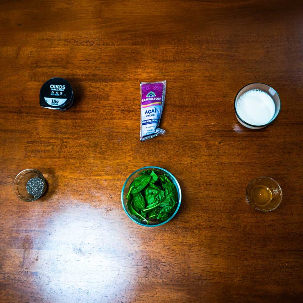 Spinach acai smoothie ingredients &ndash; fresh spinach, frozen acai, and banana for high-protein breakfast