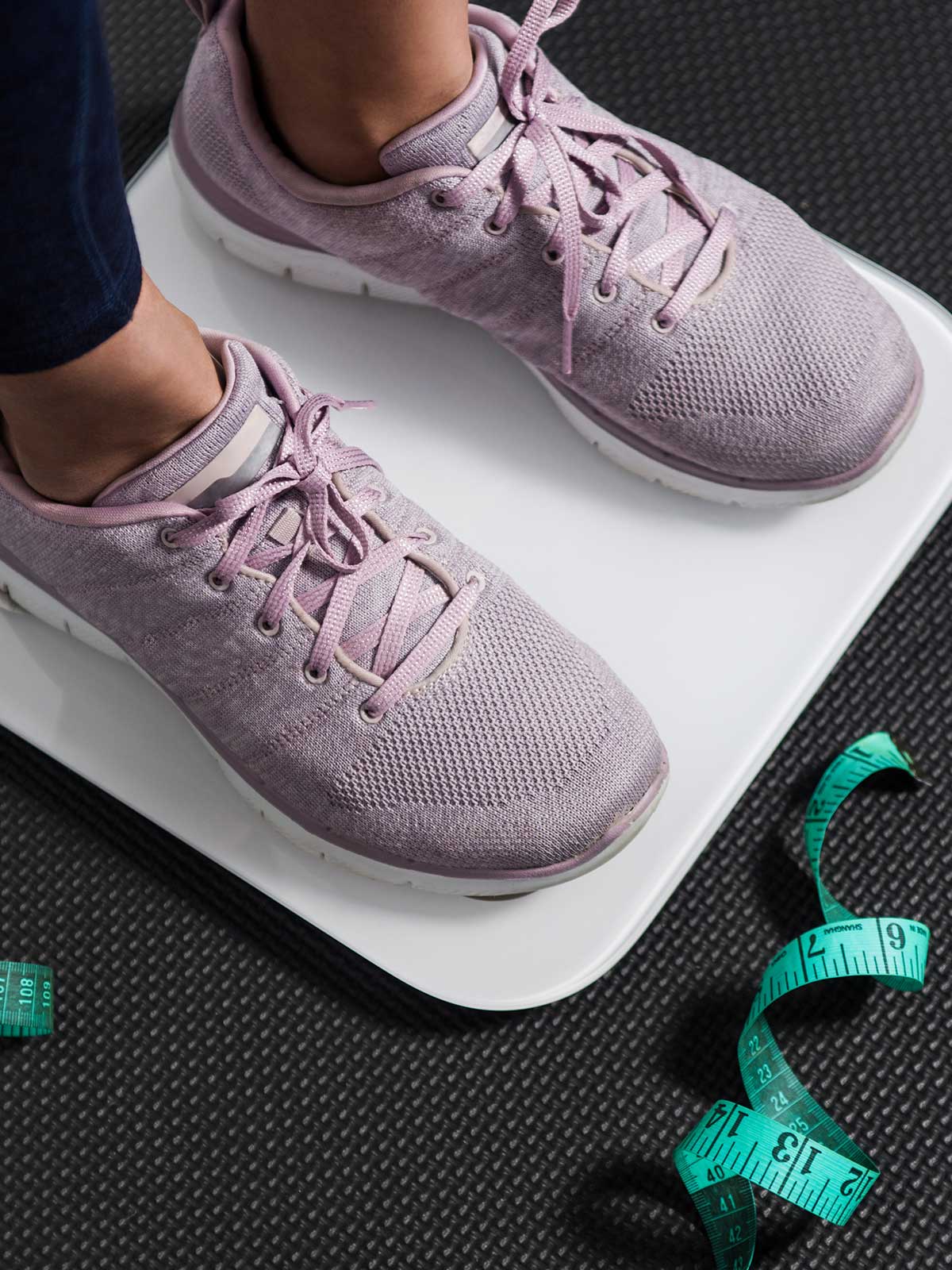 Person standing on bathroom scale &ndash; tracking progress on a high-protein diet