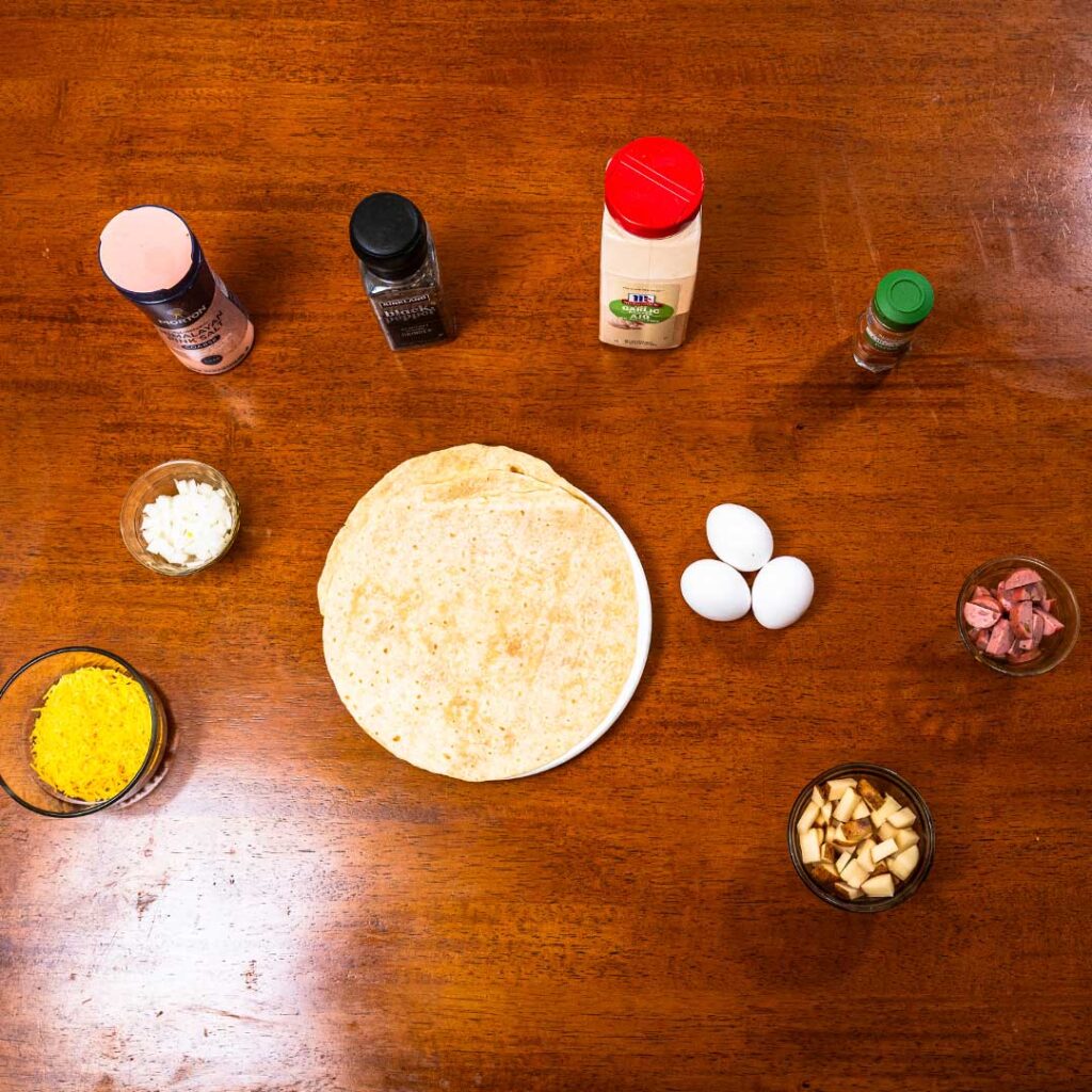 Breakfast burrito ingredients &ndash; sausage, eggs, cheese, flour tortilla for high protein meal