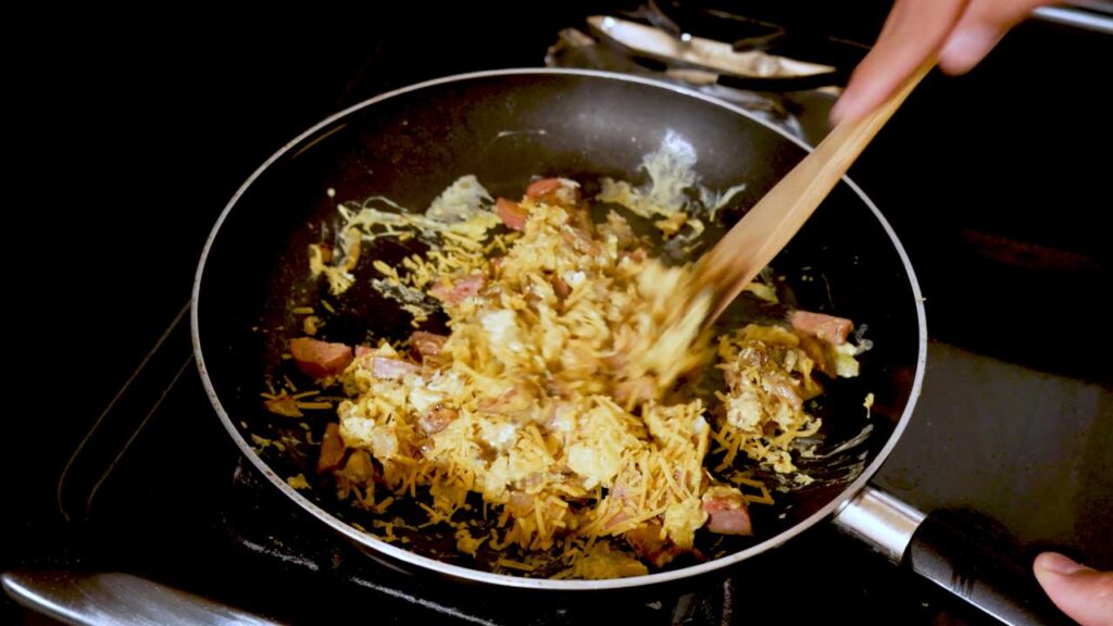 How to make breakfast burrito &ndash; step showing sausage being cooked in skillet