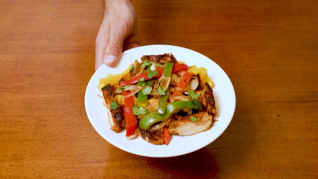 Making chicken fajitas – step 4: plating finished high-protein fajitas with toppings