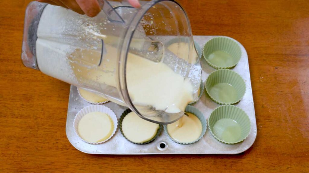 How to make cottage cheese egg bites &ndash; step showing bacon and cheese being added