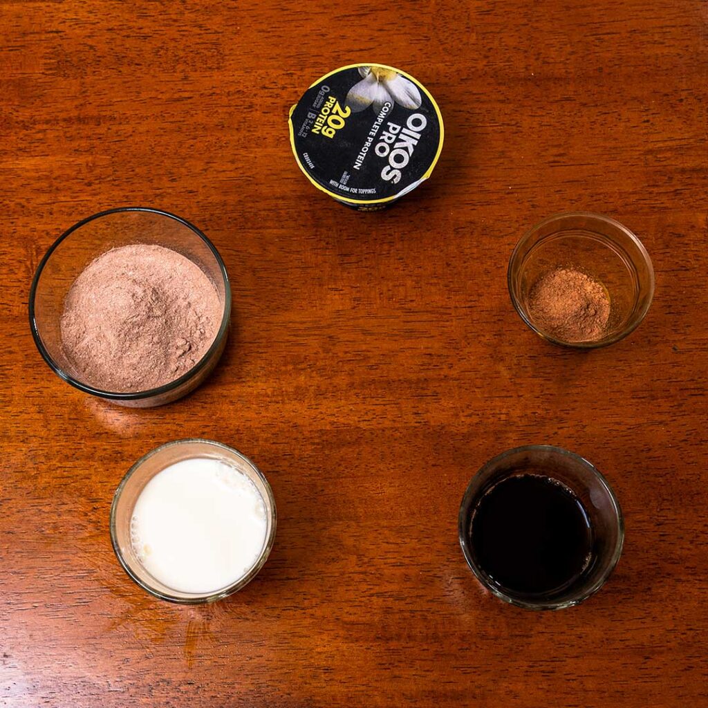 Iced mocha protein latte ingredients – espresso, chocolate syrup, milk, protein powder