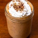 Pumpkin pie protein overnight oats hero shot -- jar with pumpkin spice and oats