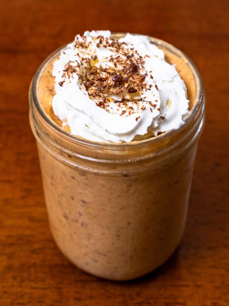 Pumpkin pie protein overnight oats hero shot -- jar with pumpkin spice and oats