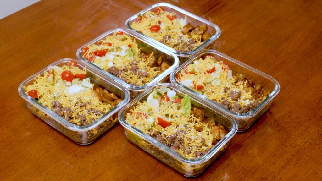 High-protein ground meat meal prep bowls with shredded cheese, lettuce and tomato