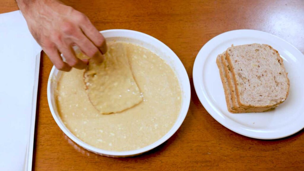 Dipping bread in the protein french toast batter, a step in the apple cinnamon recipe