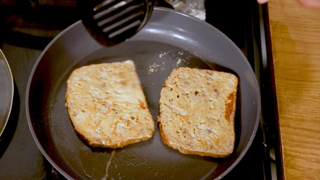 Apple cinnamon protein french toast cooking in a nonstick skillet