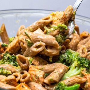 Close-up of cottage cheese chicken alfredo pasta with broccoli and penne on a fork