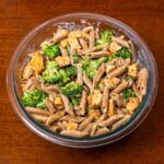 Cottage cheese chicken alfredo pasta with broccoli in a glass bowl, a high-protein dinner