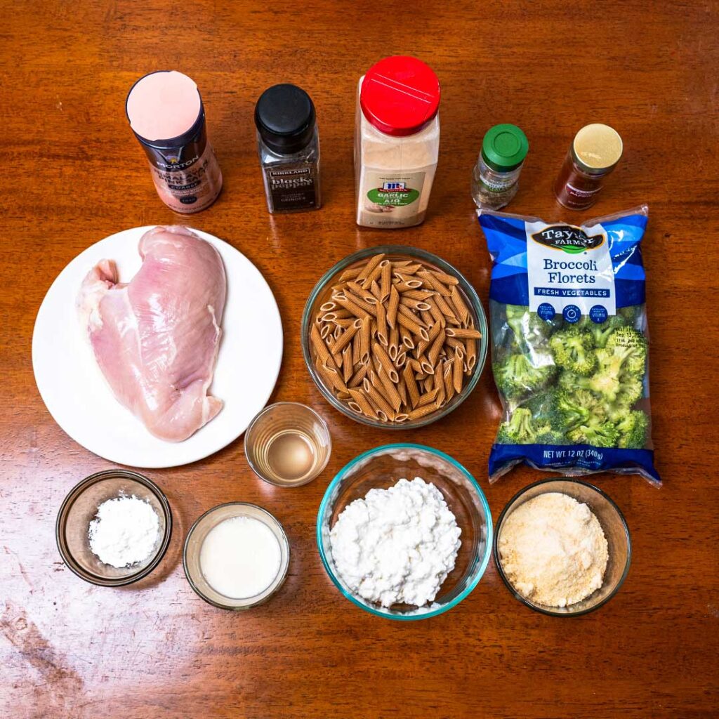 Chicken alfredo pasta ingredients, chicken breast, penne, broccoli, and cottage cheese