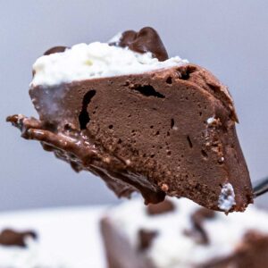 Close-up of microwave chocolate protein cheesecake with whipped cream and chocolate chips