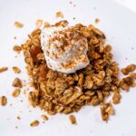 High-protein apple crisp with an oat and pecan topping, served with whipped cream