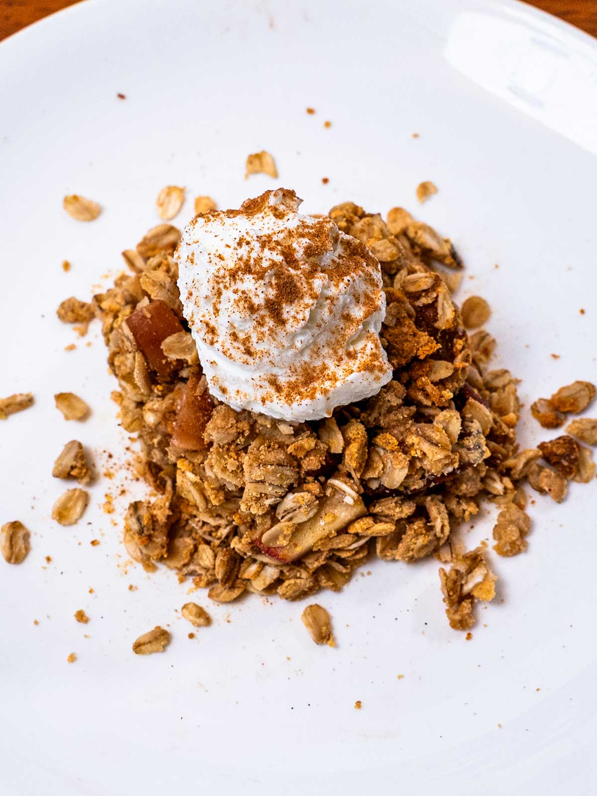 High-protein apple crisp with an oat and pecan topping, served with whipped cream