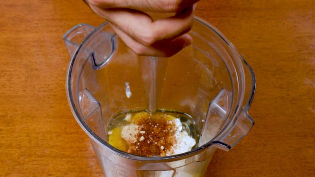 Adding spices to eggs and cottage cheese in a blender
