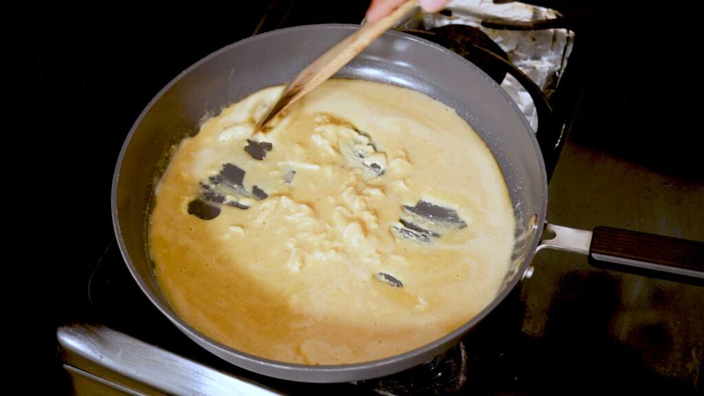 Stirring the cottage cheese scrambled eggs as they set in the pan