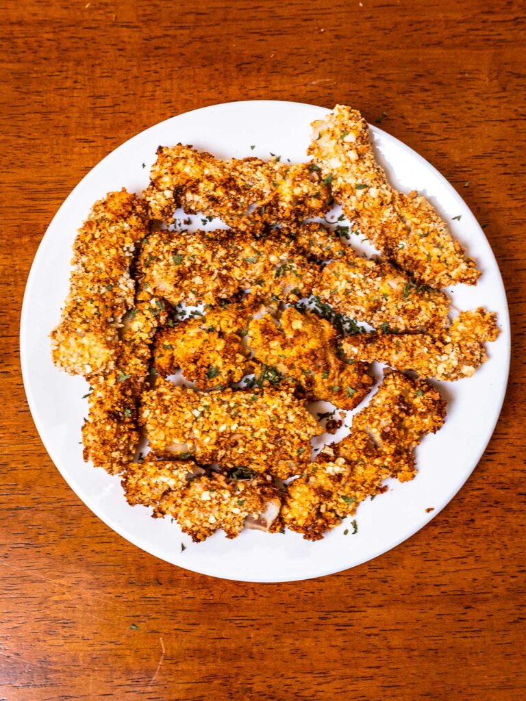 Golden crispy air fryer fish sticks on a white plate, easy high protein dinner
