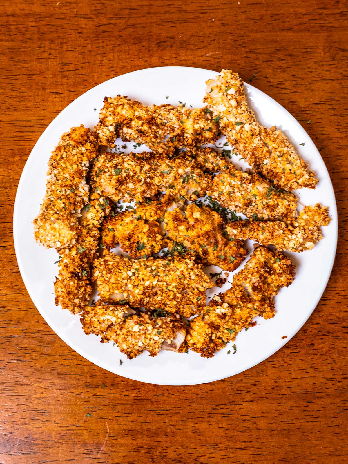 Golden crispy air fryer fish sticks on a white plate, easy high protein dinner
