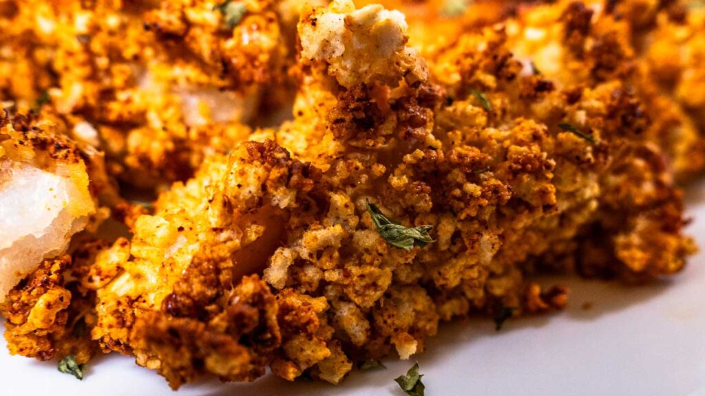 Close up of a crispy breaded air fryer fish stick with golden crunchy crumbs