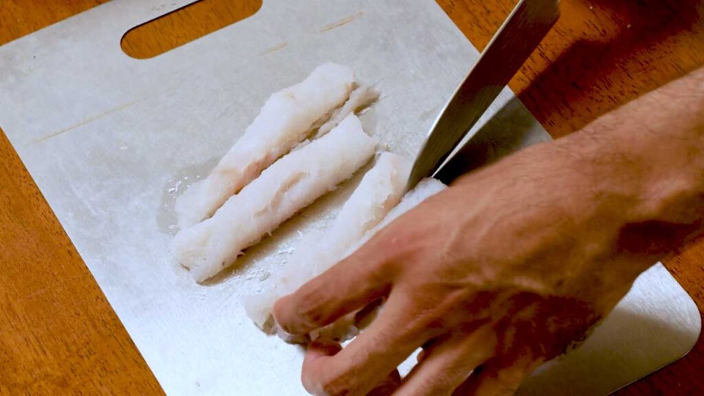 How to make air fryer fish sticks, cutting raw white fish fillets into strips