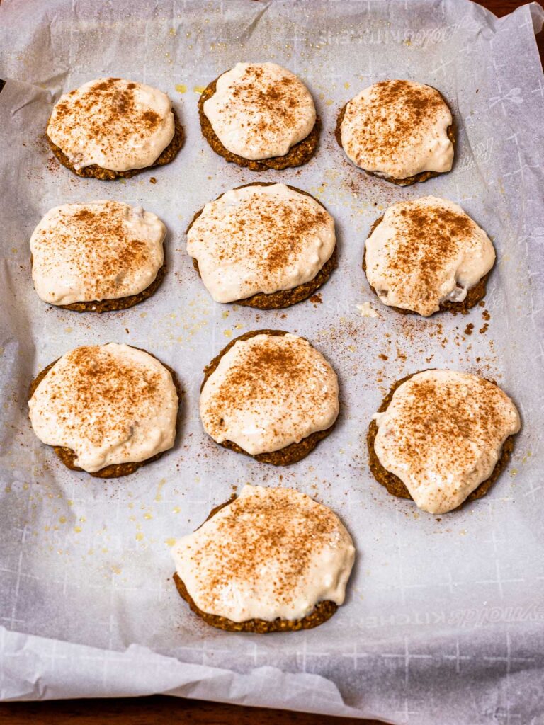Baked gingerbread protein cookies with white icing, dusted with cinnamon