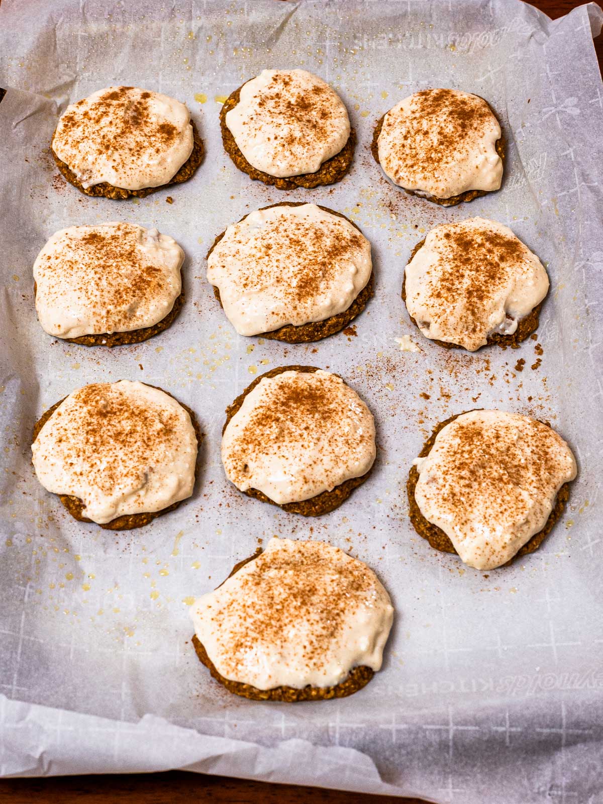 Baked gingerbread protein cookies with white icing, dusted with cinnamon