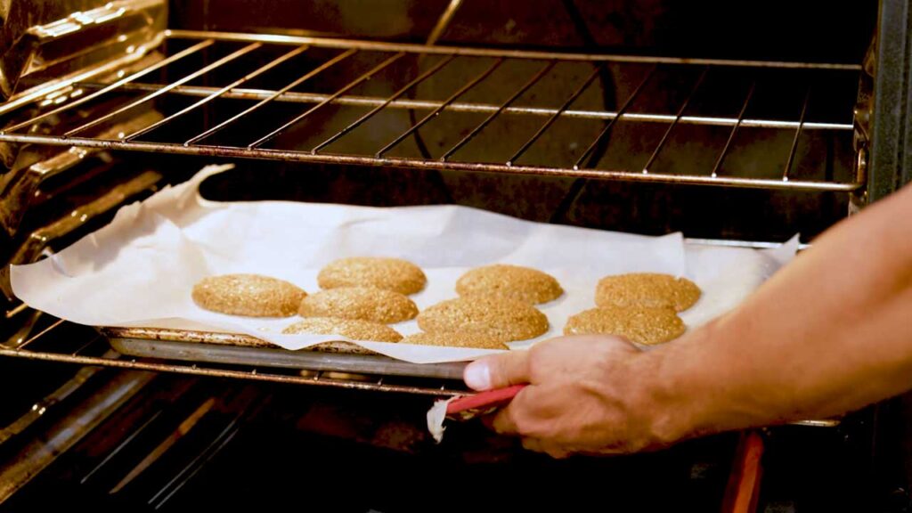 Baking gingerbread protein cookies on a parchment-lined sheet in the oven